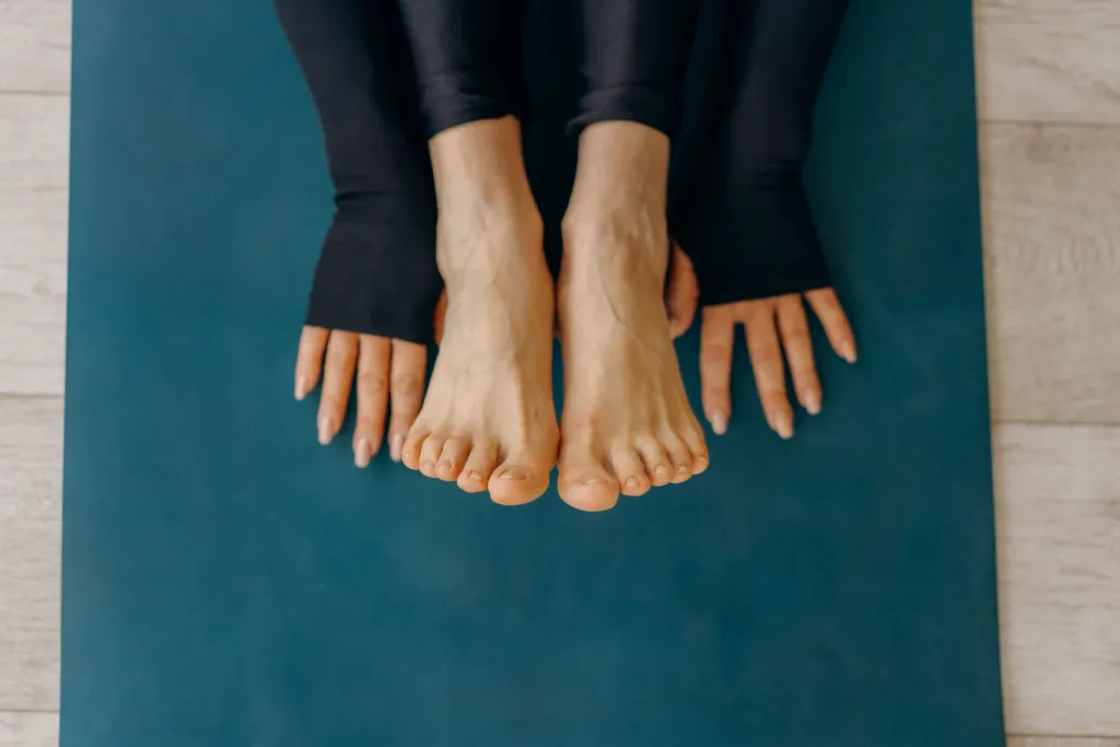 Des mains et des pieds posés sur un tapis de sol